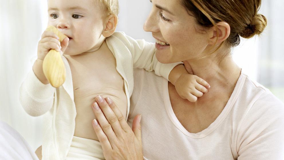 Mum massaging baby's tummy - Weleda